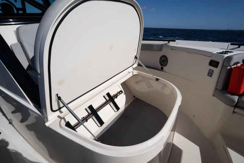Slide: The Image of 2024 Scout 330 LXF boat storage compartment open on deck. - 27
