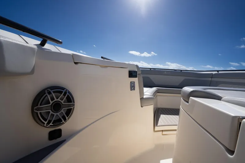 Slide: The Image of 2024 Scout 330 LXF boat interior with seating and speaker under clear blue sky. - 32