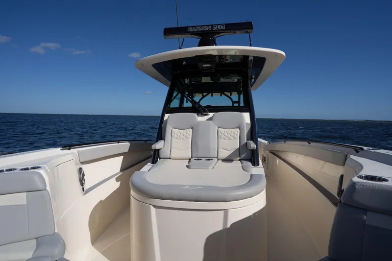 Slide: The Image of 2024 Scout 330 LXF boat on open water, featuring sleek seating and modern design. - 44