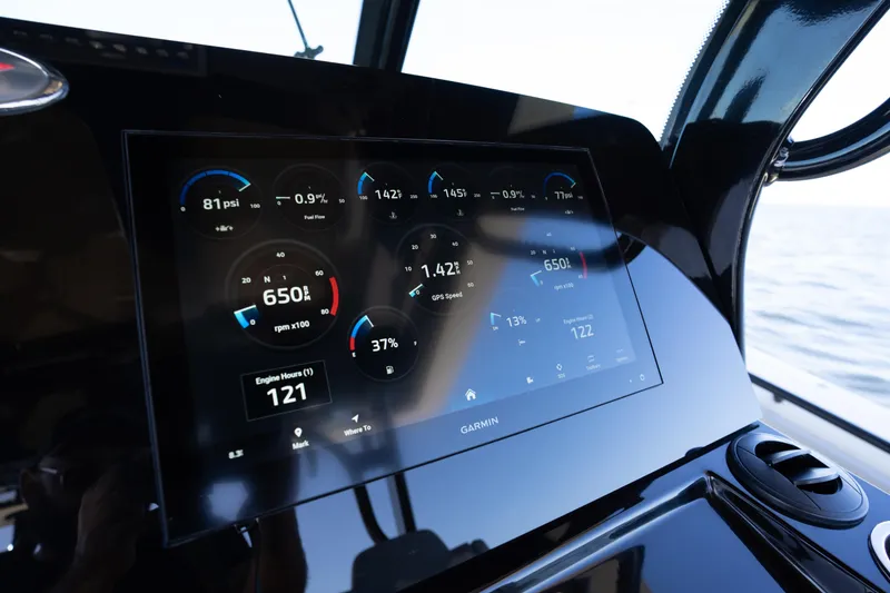 Slide: The Image of 2024 Scout 330 LXF dashboard with Garmin display showing engine metrics. - 48