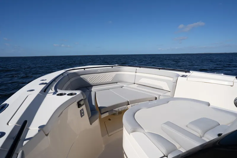 Slide: The Image of 2024 Scout 330 LXF boat interior with luxurious seating on open water. - 55