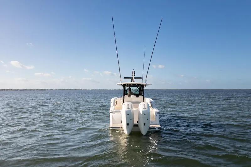 Slide: The Image of 2024 Scout 330 LXF boat on open water, rear view with dual engines. - 6