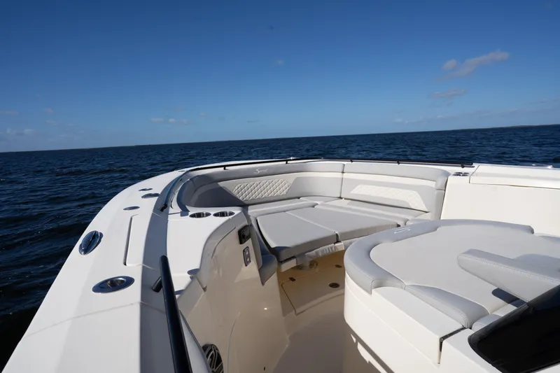 Slide: The Image of 2024 Scout 330 LXF boat interior with luxurious seating on open water. - 63