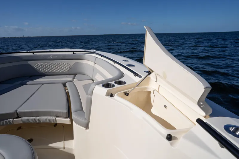 Slide: The Image of 2024 Scout 330 LXF boat interior with seating and storage, on open water. - 64