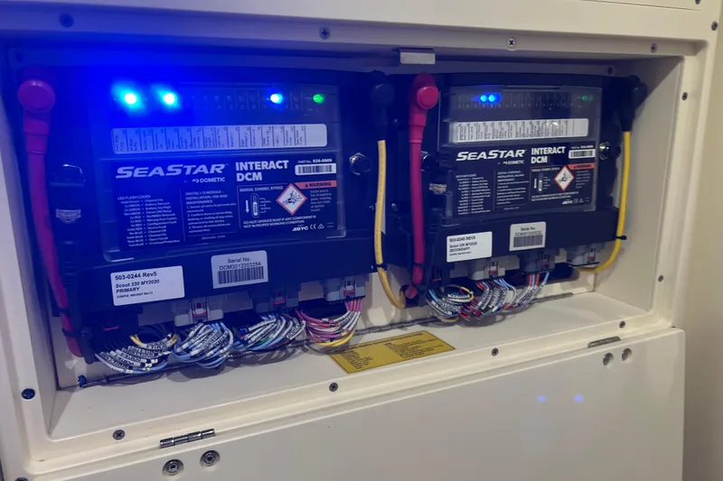 Slide: The Image of 2024 Scout 330 LXF electrical panel with SeaStar Interact DCM units and wiring. - 83