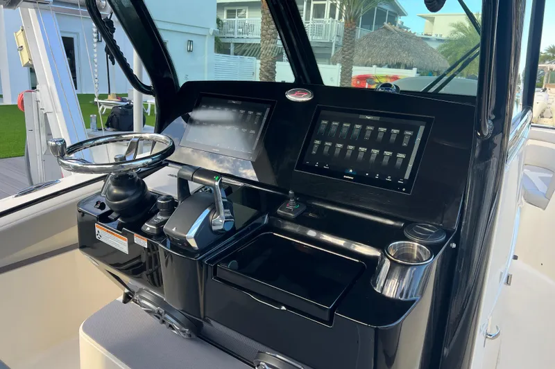 Slide: The Image of 2024 Scout 330 LXF boat dashboard with steering wheel and digital controls. - 85