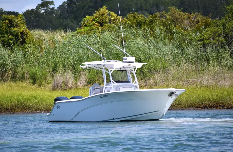 Slide: The Image of 2020 Sea Fox 288 Commander boat cruising on a calm waterway with lush greenery. - 11