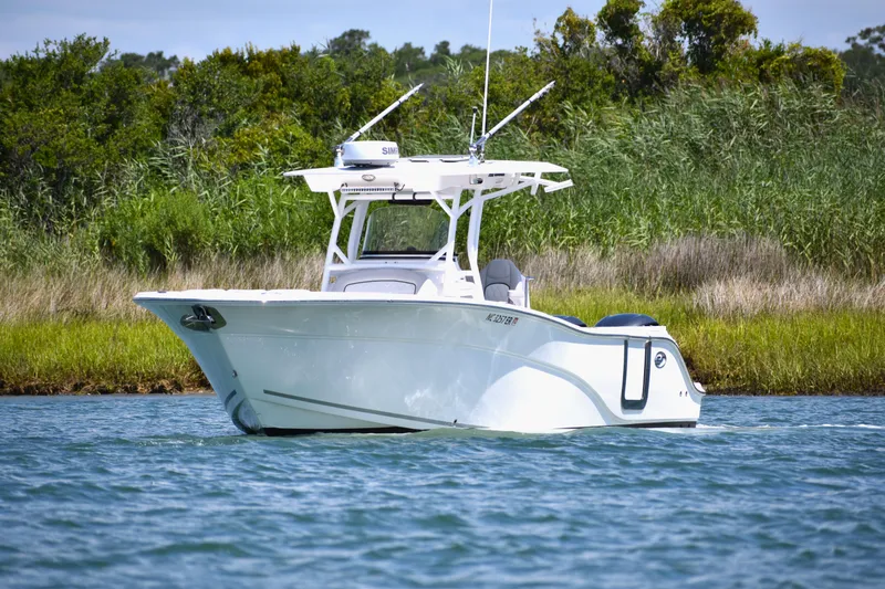Slide: The Image of 2020 Sea Fox 288 Commander boat on calm water, surrounded by lush greenery. - 9
