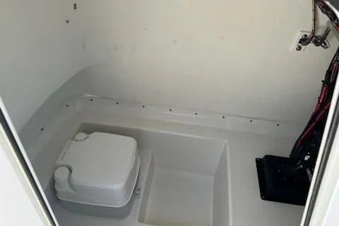 Slide: The Image of 2020 Parker 2501 Center Console boat interior with portable toilet and wiring. - 11