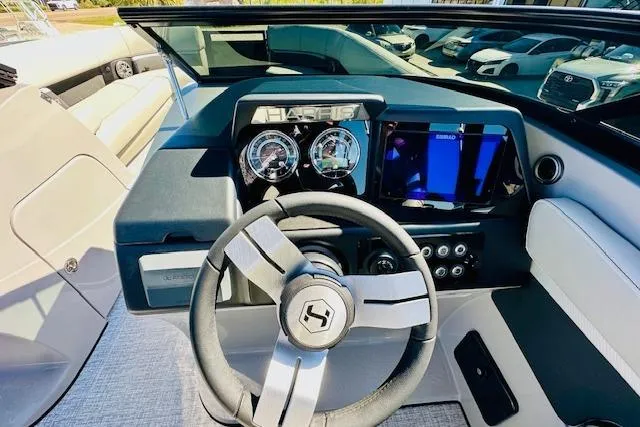 Slide: The Image of 2026 Harris Solstice DC 250 boat dashboard with steering wheel and digital display. - 13
