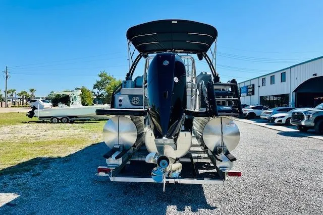 Slide: The Image of 2026 Harris Solstice DC 250 pontoon boat on trailer, parked outdoors under clear blue sky. - 2
