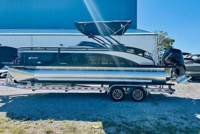 Slide: The Image of 2026 Harris Solstice DC 250 pontoon boat on a trailer, parked outdoors. - 4