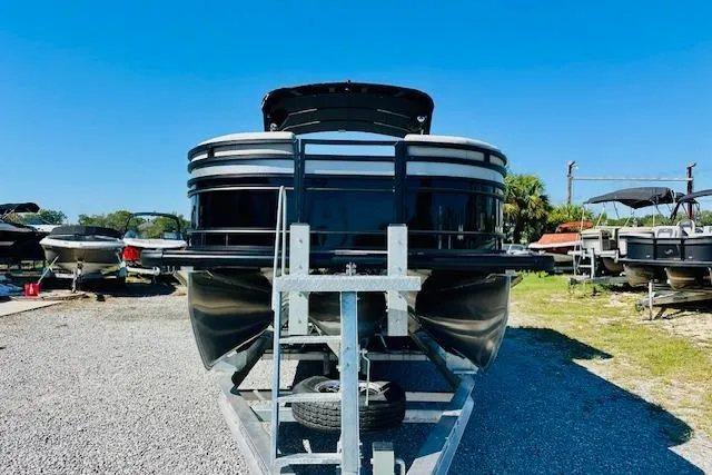 Slide: The Image of 2026 Harris Solstice DC 250 pontoon boat on trailer, parked outdoors under clear blue sky. - 6