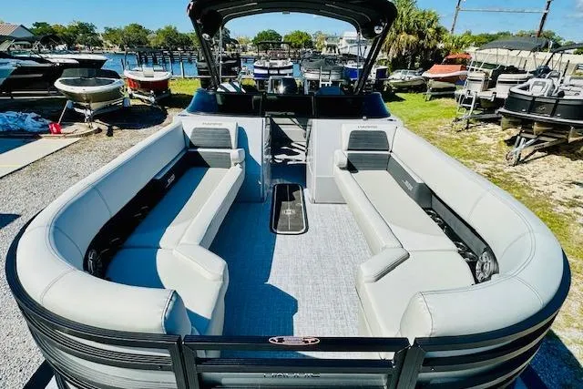 Slide: The Image of 2026 Harris Solstice DC 250 pontoon boat with spacious seating, docked at a marina. - 8