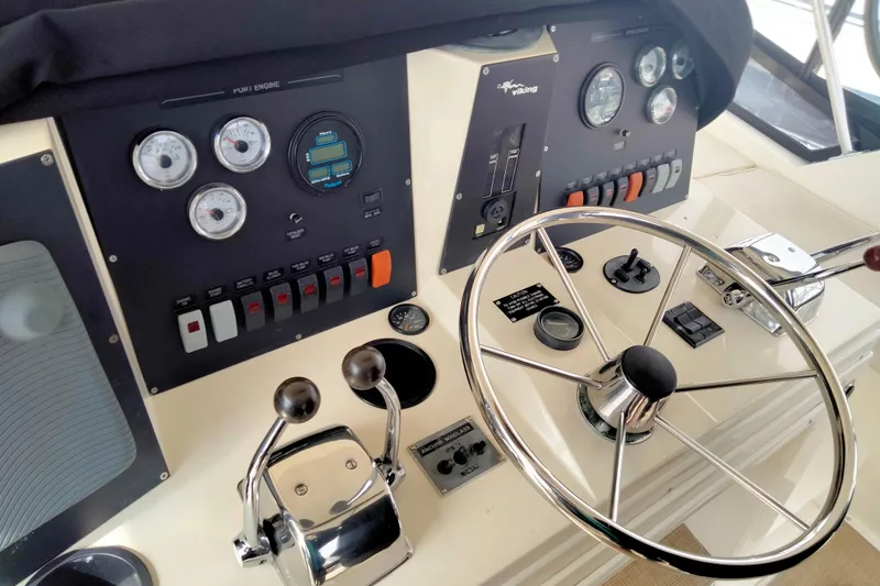 Slide: The Image of Control panel of a 1988 Viking 48 Convertible yacht with steering wheel and gauges. - 10