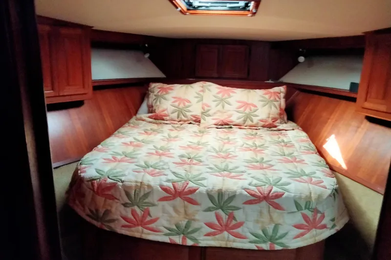 Slide: The Image of Cozy bedroom in 1988 Viking 48 Convertible yacht with floral bedding and wood paneling. - 14