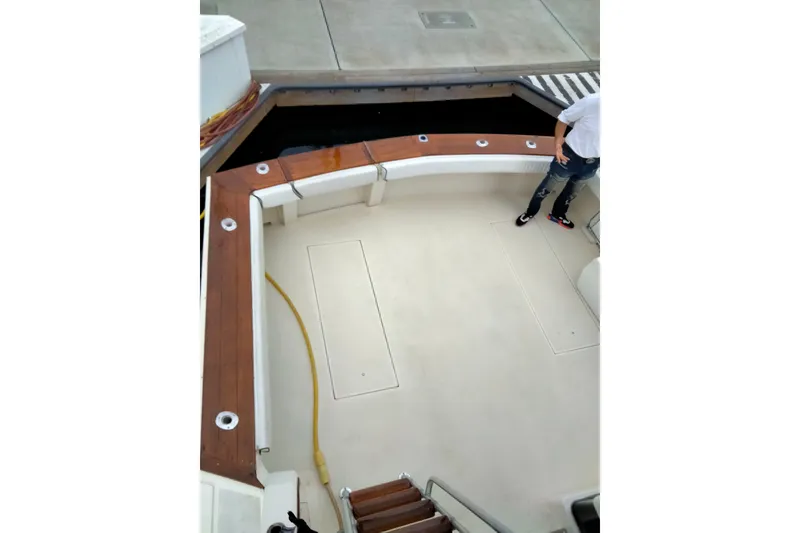 Slide: The Image of 1988 Viking 48 Convertible boat deck with wooden trim and fishing rod holders. - 5