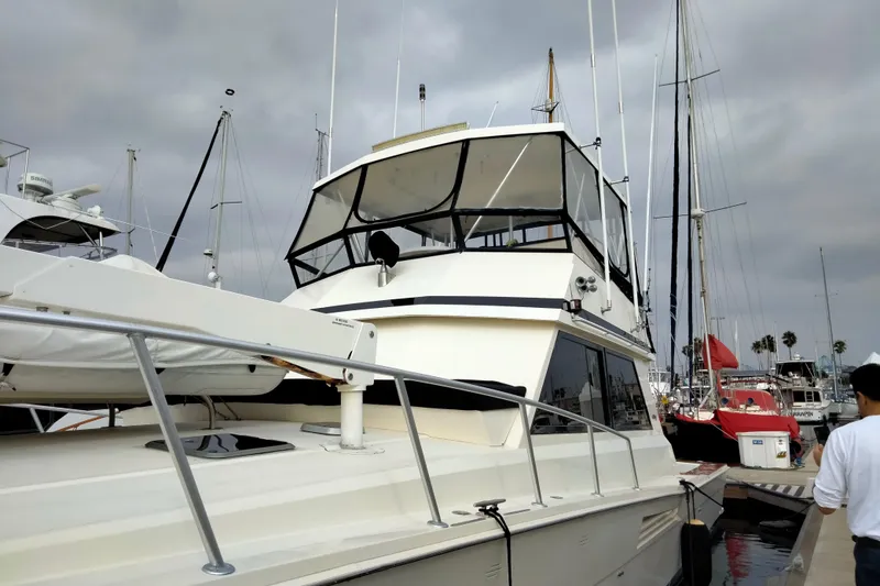 Slide: The Image of 1988 Viking 48 Convertible yacht docked at marina under cloudy skies. - 8