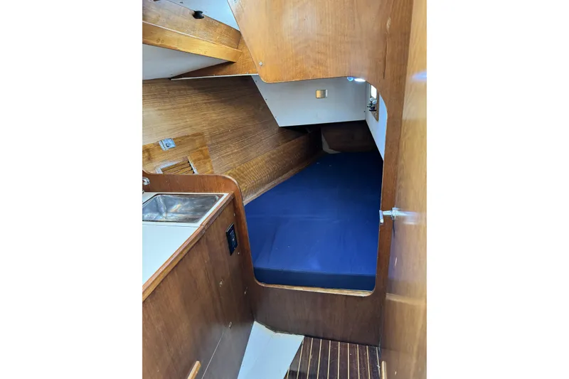 Slide: The Image of Interior of 1984 Barberis 38 sailboat with wooden finish and blue bedding. - 14