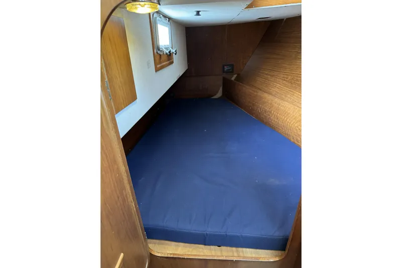 Slide: The Image of Interior cabin of 1984 Barberis 38 sailboat with blue mattress and wooden paneling. - 15