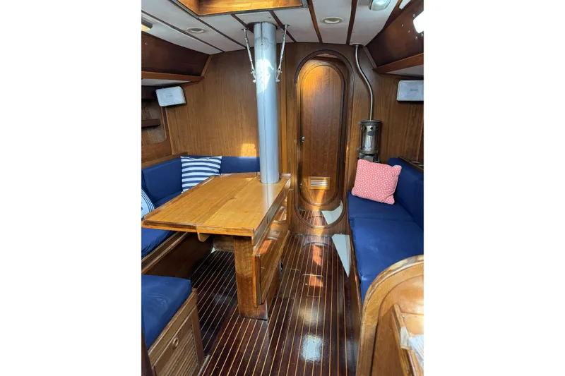 Slide: The Image of Interior of 1984 Barberis 38 sailboat with wooden table and blue seating. - 17