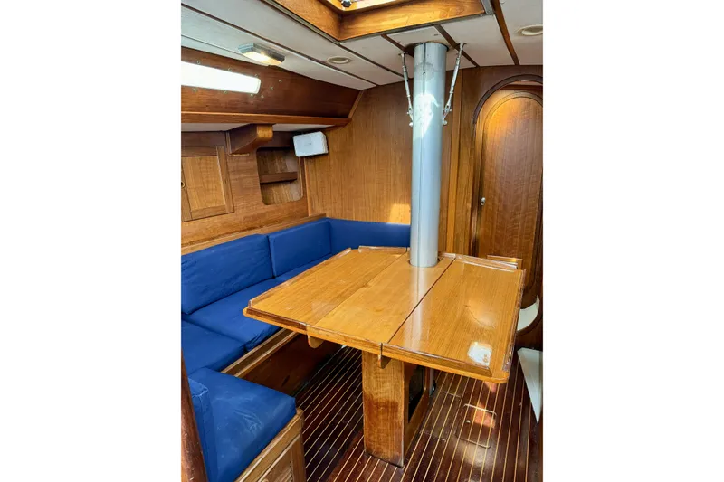 Slide: The Image of 1984 Barberis 38 yacht interior with wooden table, blue seating, and polished wood finish. - 18