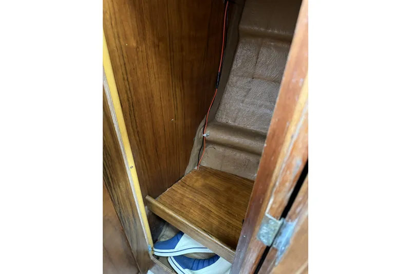 Slide: The Image of Wooden interior of 1984 Barberis 38 boat, featuring storage space and visible wiring. - 26
