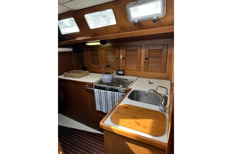 Slide: The Image of Barberis 38 yacht kitchen interior, 1984 model, featuring wooden cabinets and a compact sink area. - 7