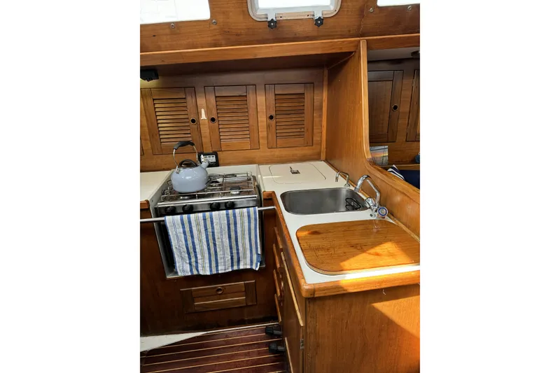 Slide: The Image of Barberis 38 yacht kitchen interior, featuring wooden cabinetry, stove, and sink, 1984 model. - 8