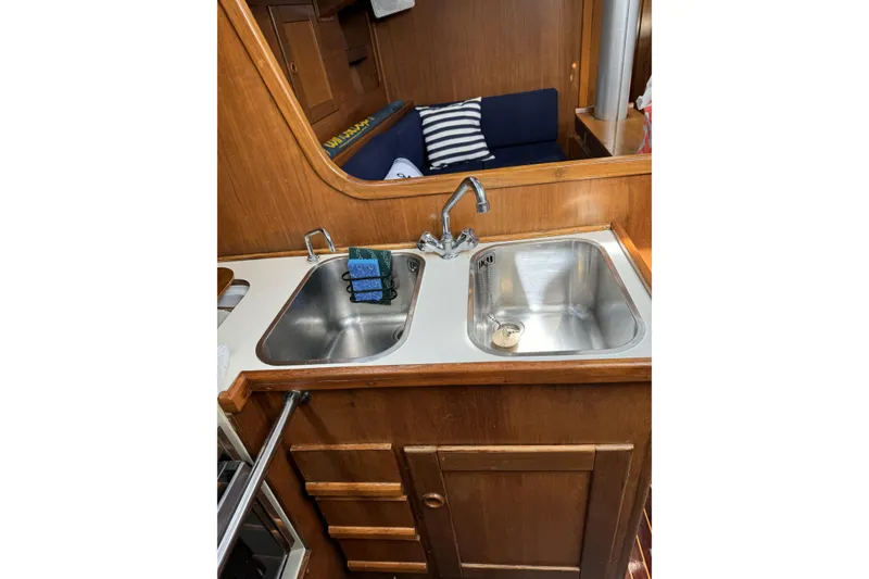 Slide: The Image of Barberis 38 yacht kitchen with dual sinks, wooden cabinetry, and cozy seating, 1984 model. - 9