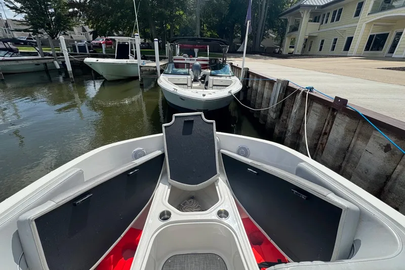 Slide: The Image of 2023 Bayliner VR6 Bowrider OB docked at marina, open storage compartments visible. - 12