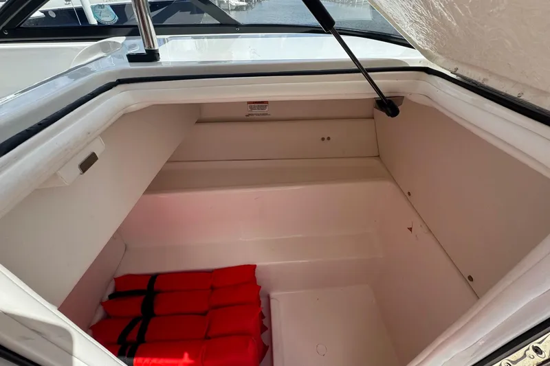 Slide: The Image of 2023 Bayliner VR6 Bowrider OB storage compartment with red life jackets inside. - 17
