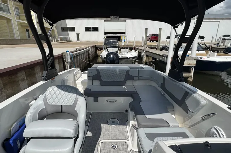 Slide: The Image of 2023 Bayliner VR6 Bowrider OB interior with spacious seating at a marina dock. - 20