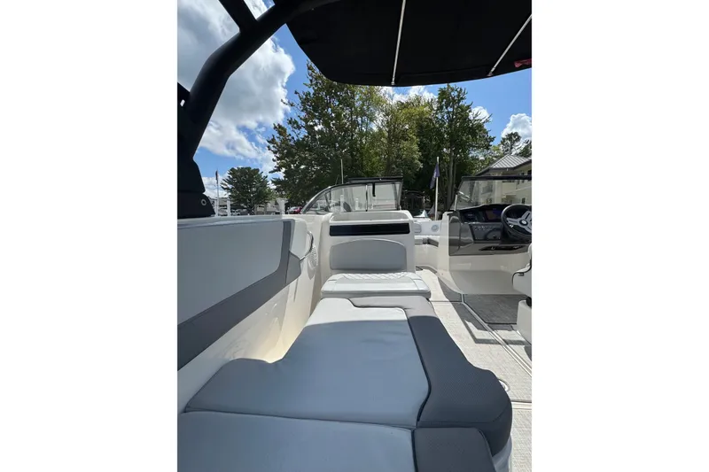 Slide: The Image of 2023 Bayliner VR6 Bowrider OB interior with seating and steering console under a sunny sky. - 23