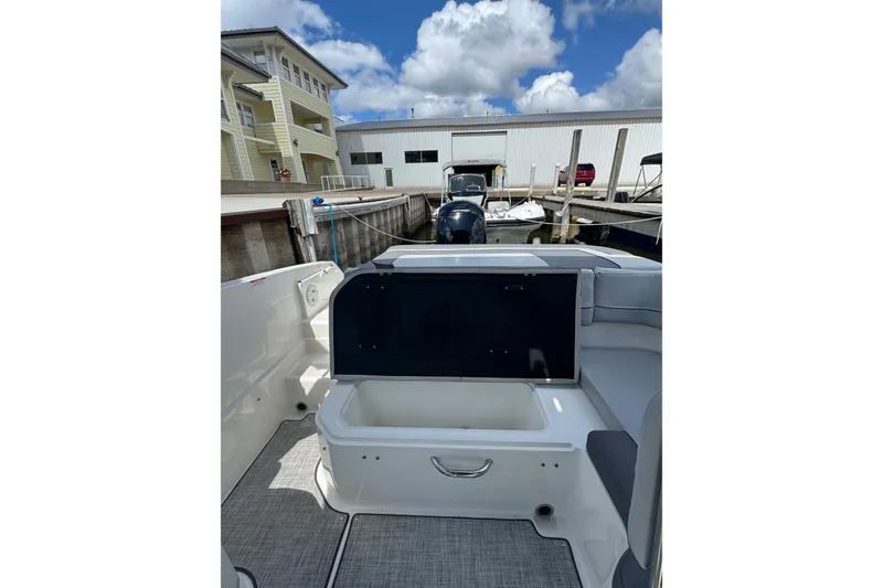 Slide: The Image of 2023 Bayliner VR6 Bowrider OB at dock, showcasing seating and storage area. - 24