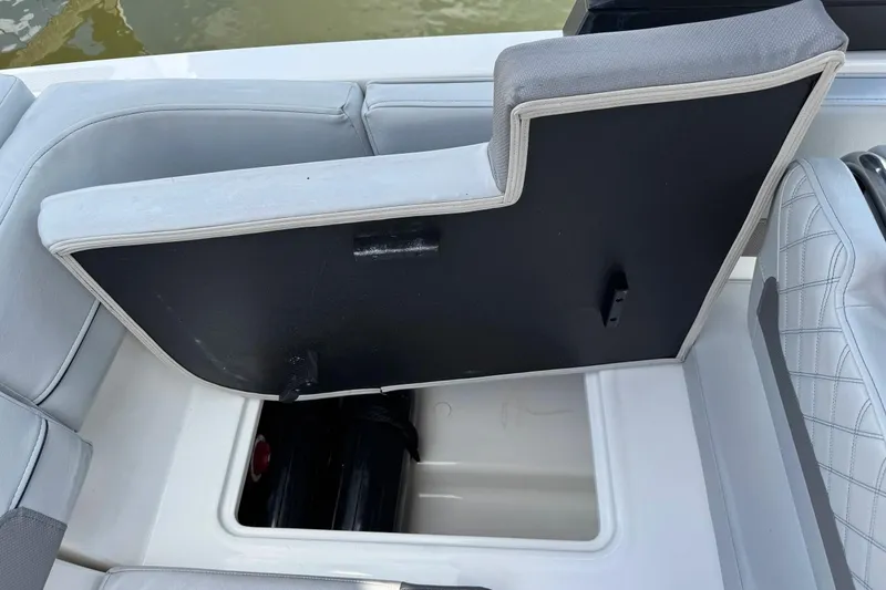 Slide: The Image of 2023 Bayliner VR6 Bowrider OB storage compartment with open seat cushion, revealing interior space. - 26