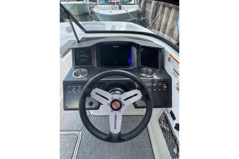 Slide: The Image of 2023 Bayliner VR6 Bowrider OB dashboard with steering wheel and control panel. - 5