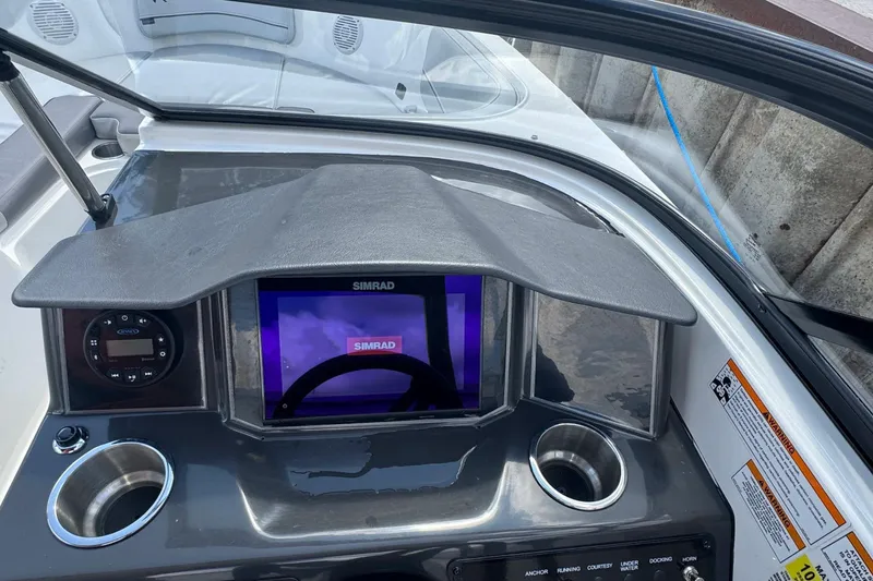 Slide: The Image of 2023 Bayliner VR6 Bowrider OB dashboard with Simrad display and cup holders. - 6