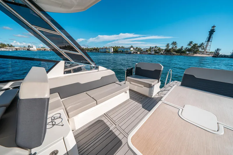 Slide: The Image of Aquila 32 Sport 2022 boat interior with ocean view and lighthouse in background. - 11