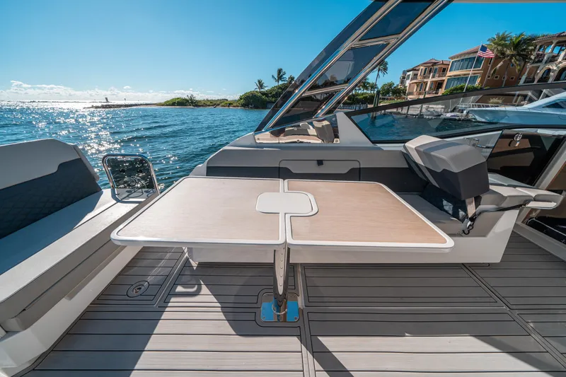 Slide: The Image of 2022 Aquila 32 Sport yacht interior with table, ocean view, and luxury seating. - 13