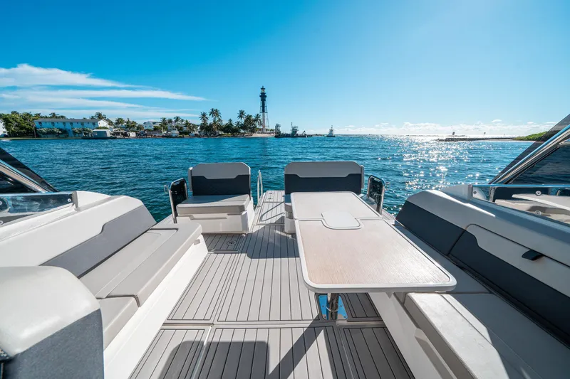 Slide: The Image of Aquila 32 Sport 2022 boat interior with ocean view and lighthouse in background. - 2