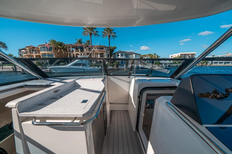 Slide: The Image of Aquila 32 Sport 2022 yacht interior with waterfront view and luxury homes. - 25