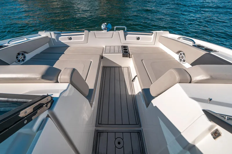 Slide: The Image of Aquila 32 Sport 2022 boat interior with cushioned seating and cup holders on water. - 3