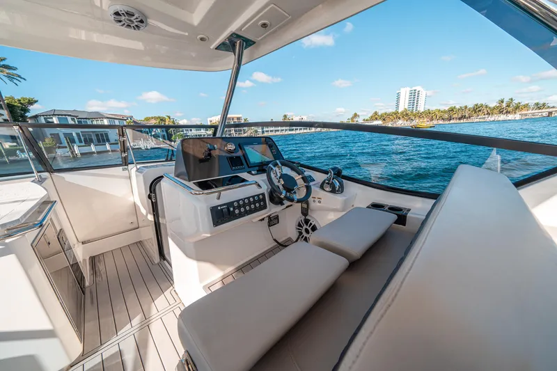 Slide: The Image of 2022 Aquila 32 Sport yacht interior with modern helm, overlooking scenic waterfront. - 38