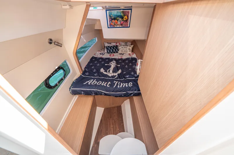 Slide: The Image of Cozy cabin interior of 2022 Aquila 32 Sport with nautical-themed bedding. - 4