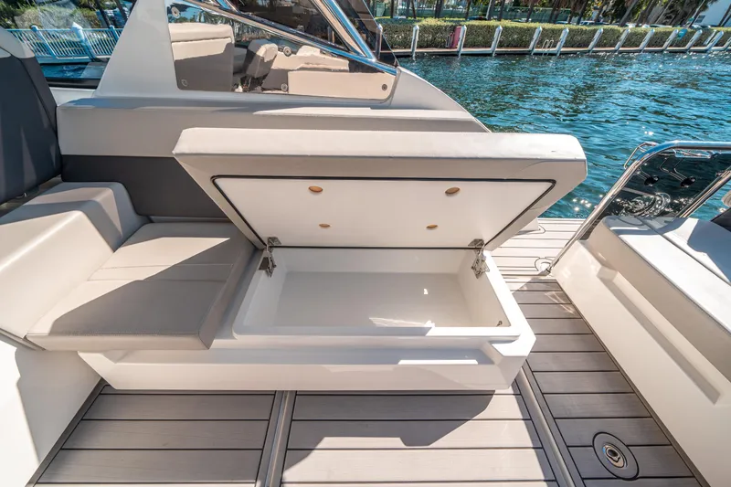 Slide: The Image of Open storage compartment on 2022 Aquila 32 Sport boat, docked by the water. - 42