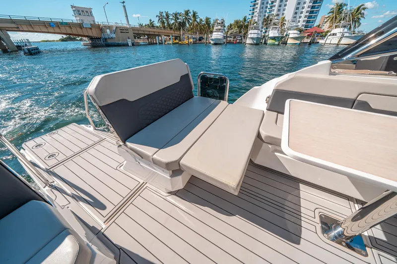 Slide: The Image of Aquila 32 Sport 2022 boat interior with seating and table, docked near a bridge. - 43