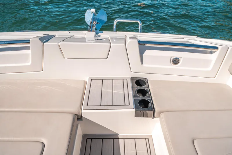 Slide: The Image of Aquila 32 Sport 2022 boat interior with seating and cup holders by the water. - 45