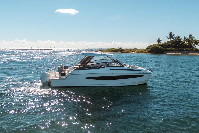 Slide: The Image of Aquila 32 Sport 2022 boat cruising on sunny, tropical waters near a lush island. - 47