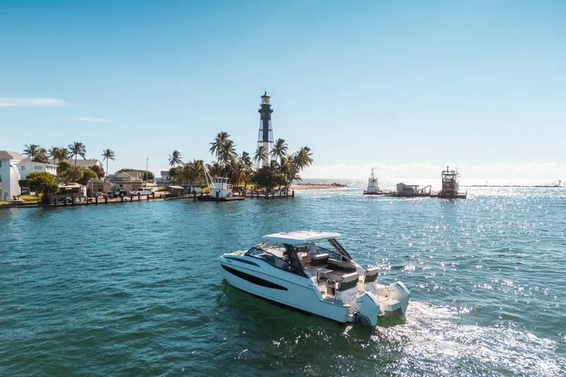 Slide: The Image of Aquila 32 Sport 2022 boat cruising near a lighthouse on a sunny day. - 49